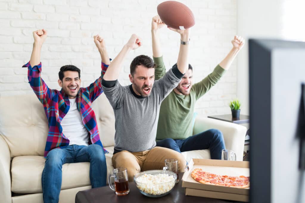 football fans celebrating a touchdown at a watch party