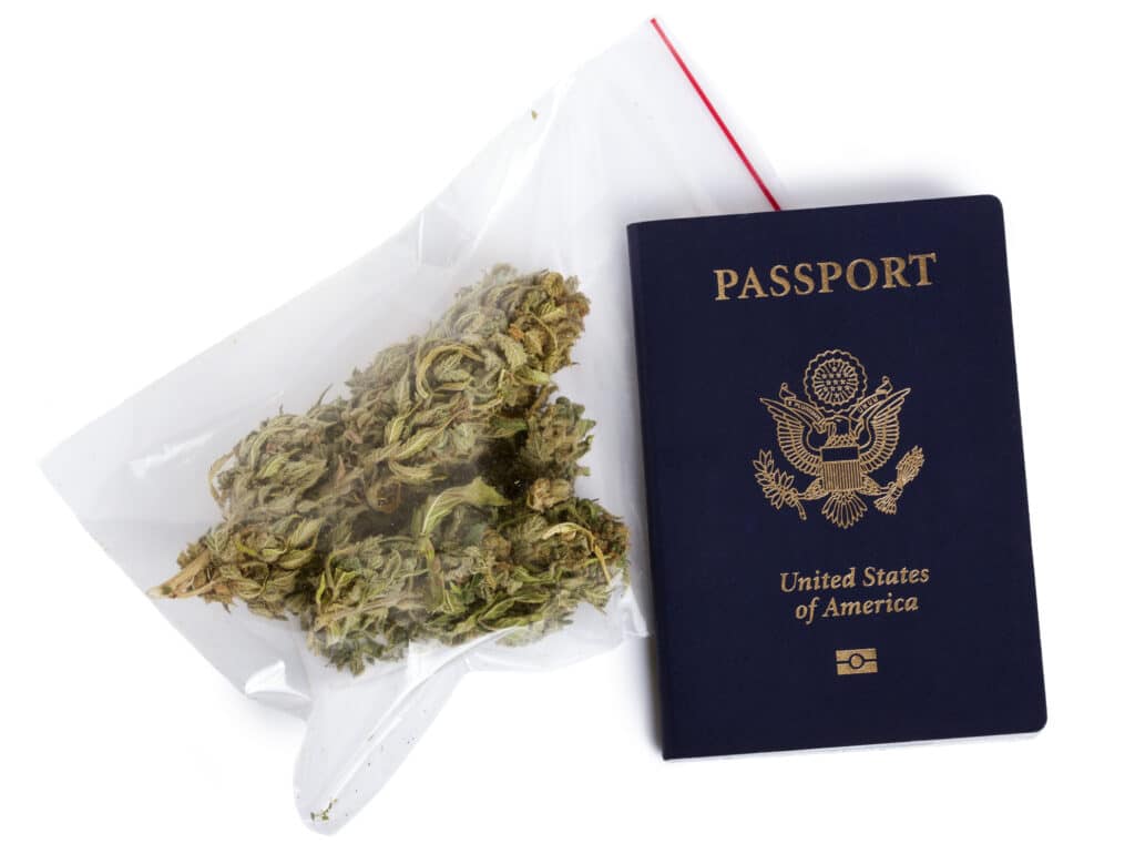 A USA passport and a zip-lock plastic bag containing cannabis buds isolated on white background.